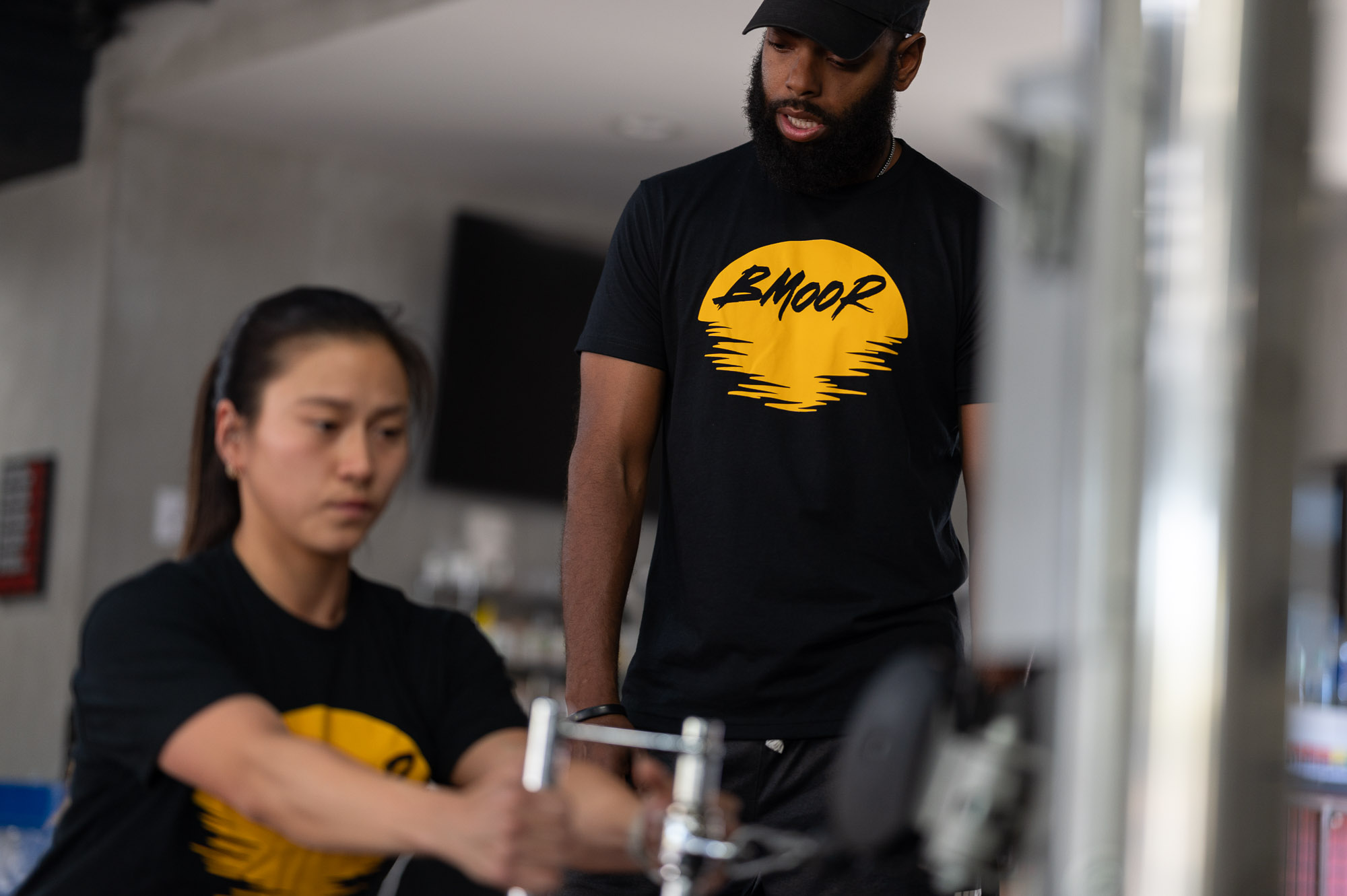 Man looking over woman as she is exercising