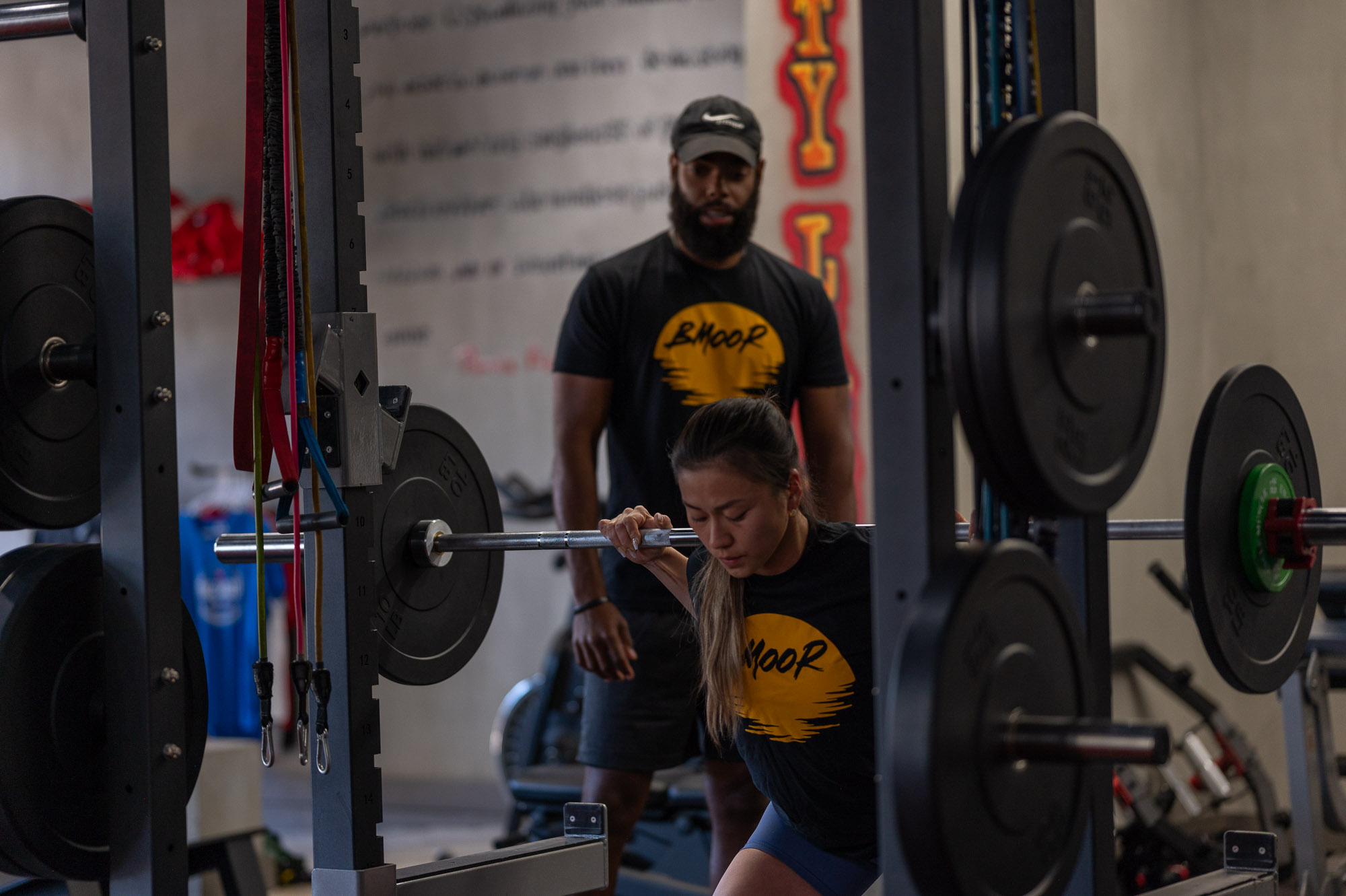 Man looking over woman as she is exercising