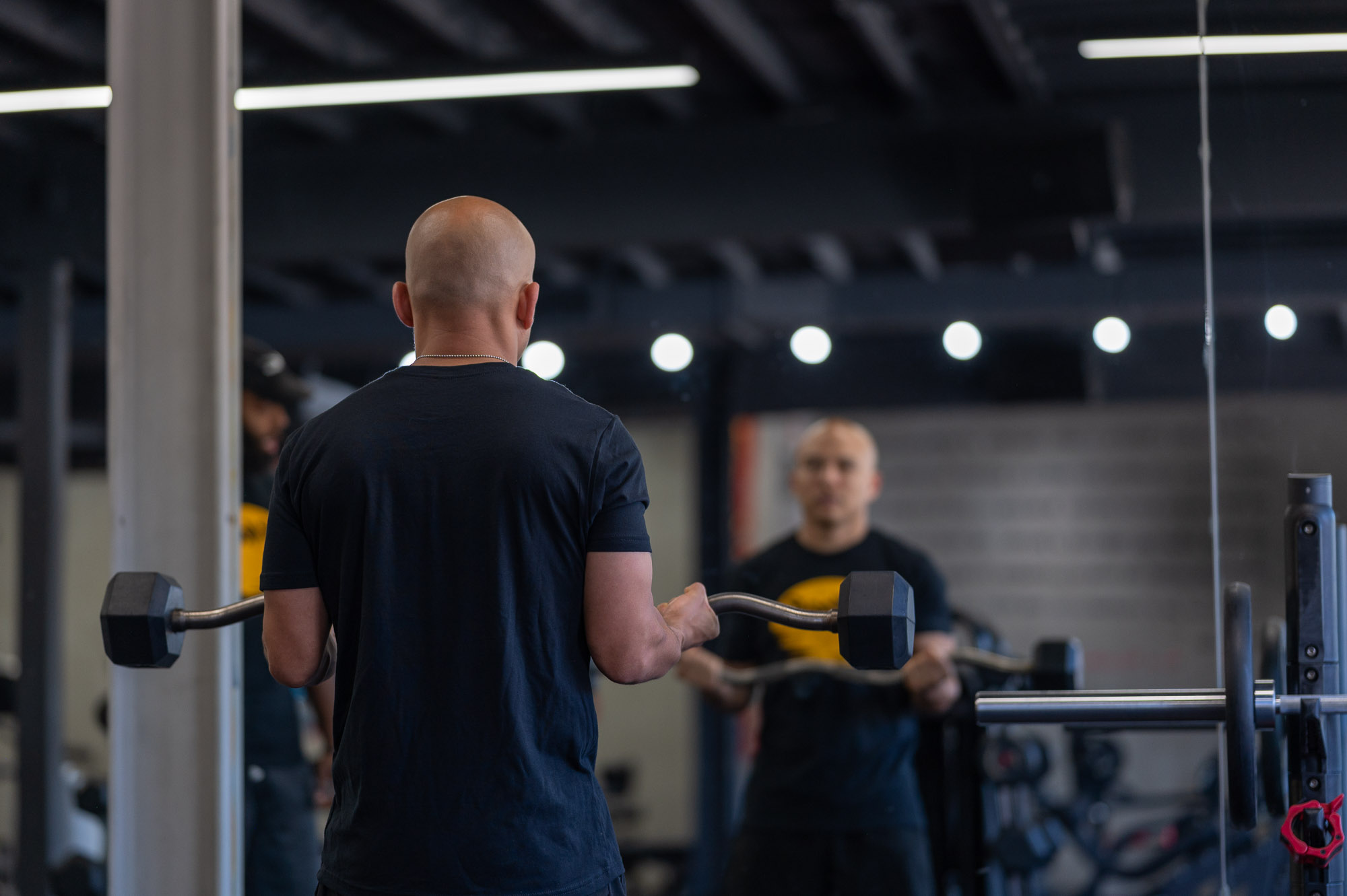 Man looking at himself in the mirror while lifting weights